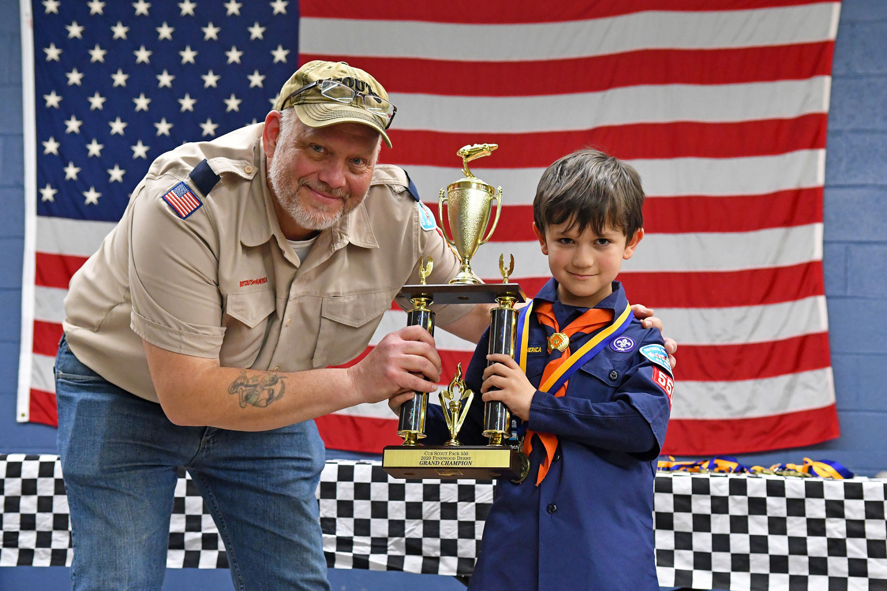 Pinewood Derby brings out Scouts' creativityPHOTO BY IAN Chini Cub Scout Pack 550 Leader Robert Van Nostrand presents Jacob Grimes with this year's Pinewood Derby Trophy.
